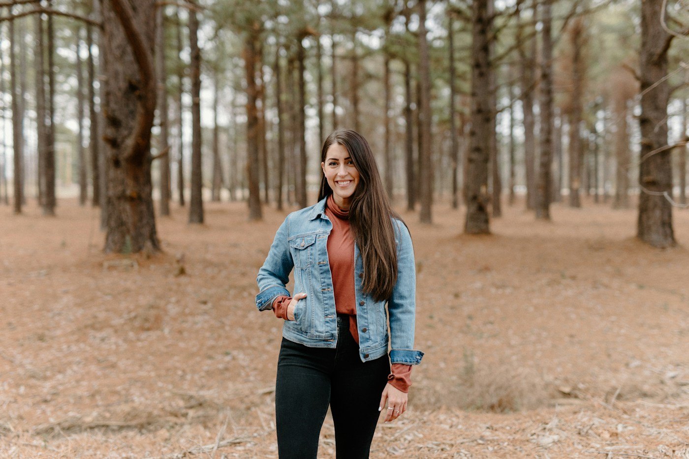 Woman walking among tall trees on a woodland path