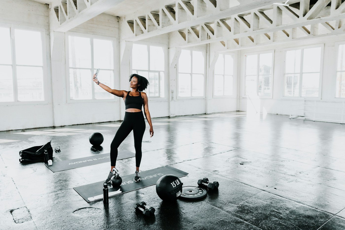 Woman lifting a weight in a bright exercise studio
